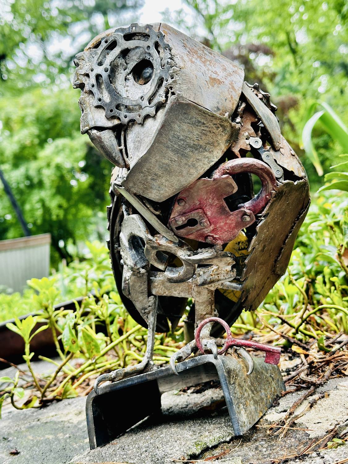 Locked Away, a welded barn owl sculpture perched on a stone wall