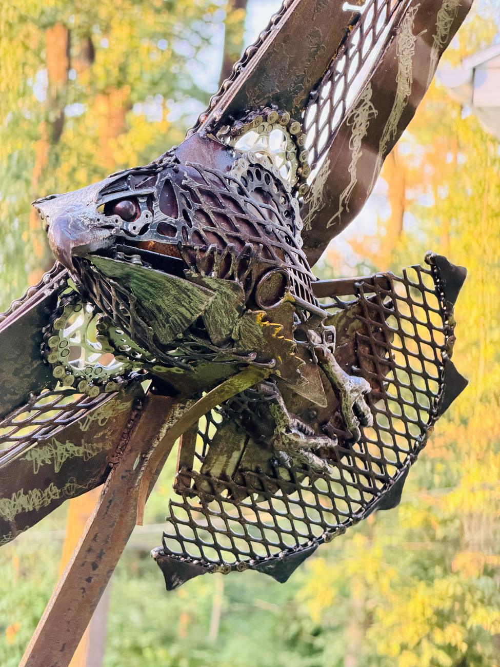 Close-up detail of Sentinel showing bicycle gears, chain, and expanded metal feather work
