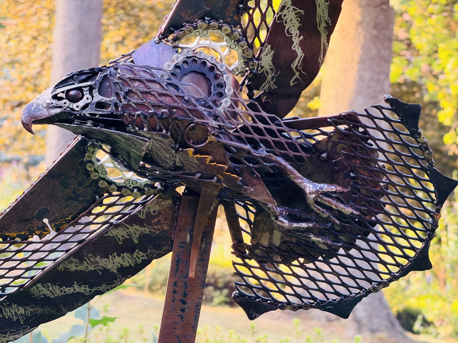 Close-up of Sentinel's head, showing bicycle gears, chain, and welded feather detail